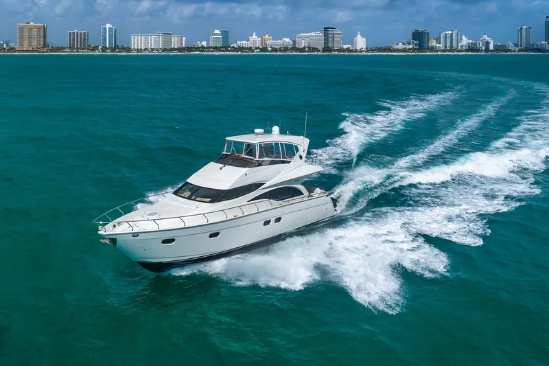 Slide: The Image of Luxurious 2005 Marquis 59 yacht cruising in turquoise waters near a city skyline. - 4