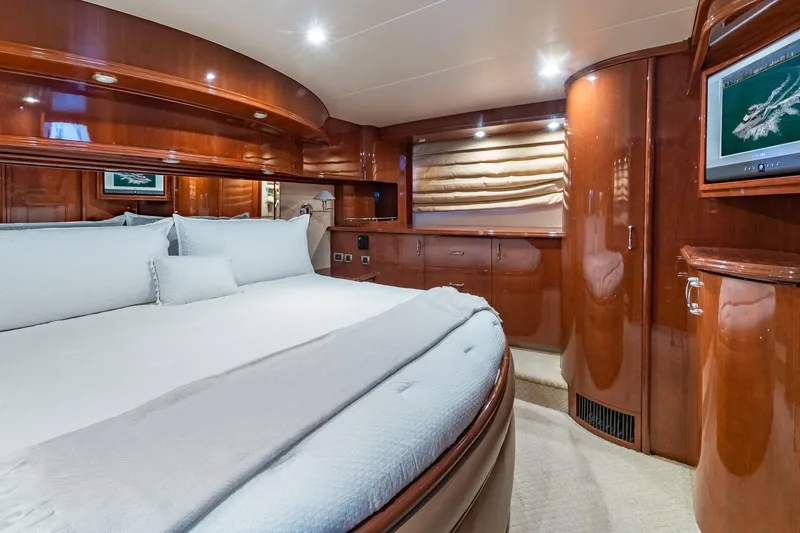 Slide: The Image of Luxurious 2005 Marquis 59 yacht bedroom with elegant wood finishes and cozy bedding. - 42