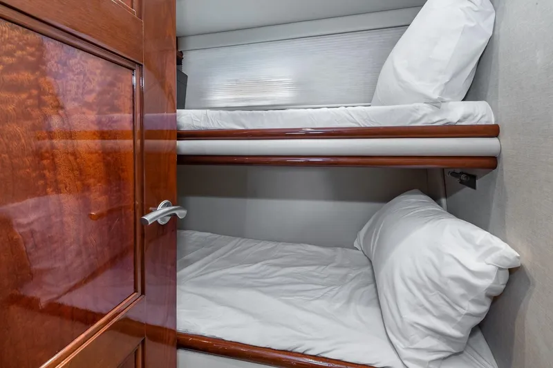 Slide: The Image of Bunk beds in 2005 Marquis 59 yacht cabin with wooden door and white bedding. - 43