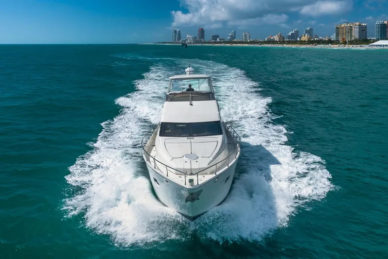 Slide: The Image of Luxurious 2005 Marquis 59 yacht cruising on blue ocean near city skyline. - 6
