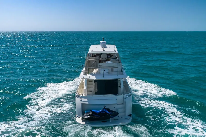 Slide: The Image of Luxury 2005 Marquis 59 yacht cruising on open sea with jet ski onboard. - 7