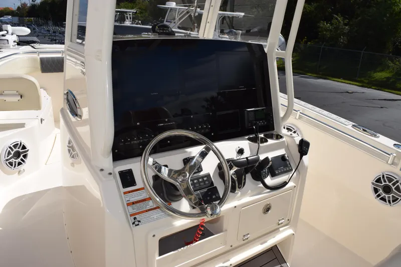 Slide: The Image of 2022 Cobia 280 Center Console boat dashboard with steering wheel and navigation controls. - 10