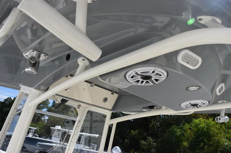 Slide: The Image of 2022 Cobia 280 Center Console boat with speakers and rod holders on the T-top. - 11