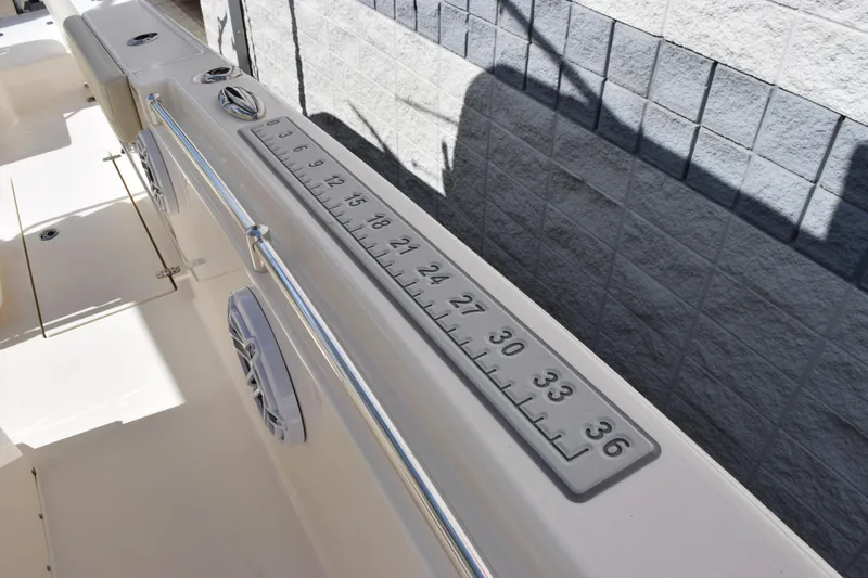 Slide: The Image of 2022 Cobia 280 Center Console boat with built-in measuring ruler on deck. - 16