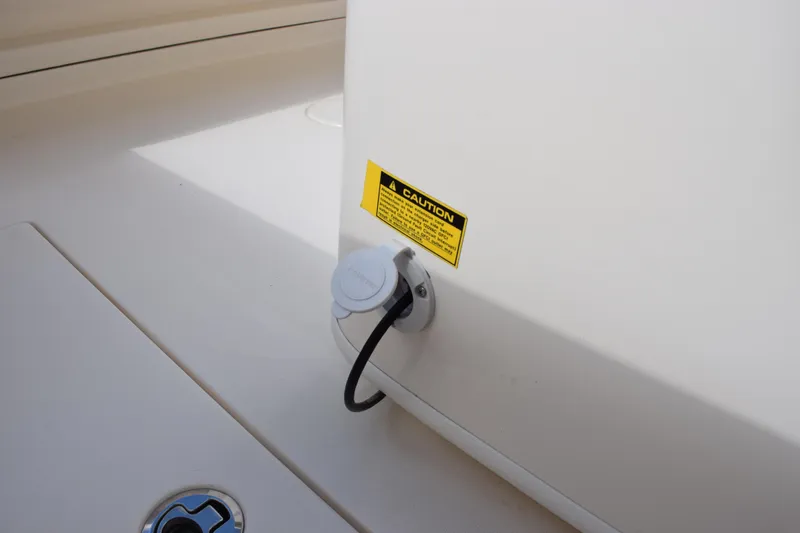 Slide: The Image of 2022 Cobia 280 Center Console boat with caution label and power outlet. - 23