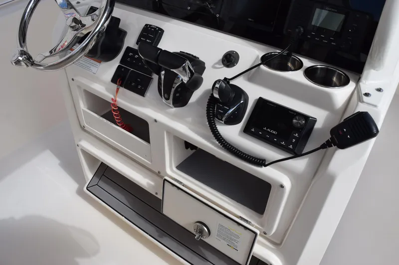 Slide: The Image of 2022 Cobia 280 Center Console dashboard with steering wheel, controls, and audio system. - 26