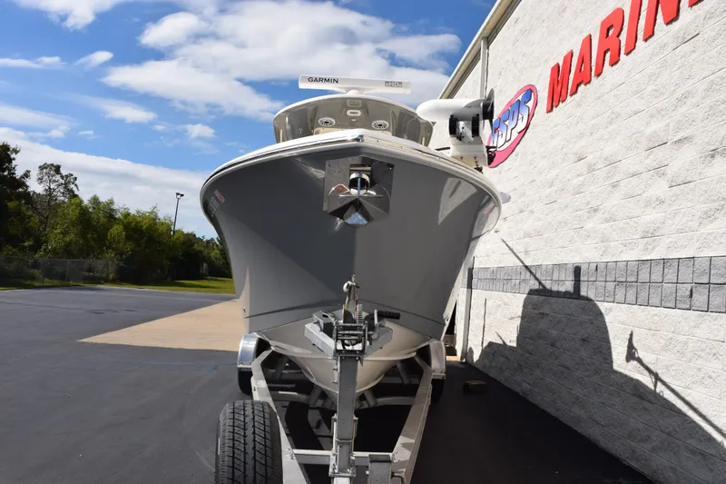 Slide: The Image of 2022 Cobia 280 Center Console boat on trailer outside marine store. - 3