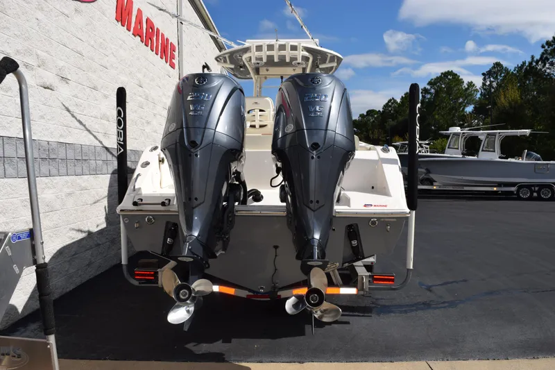 Slide: The Image of 2022 Cobia 280 Center Console boat with dual Yamaha outboard engines at a marine dealership. - 5