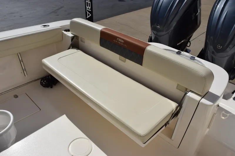 Slide: The Image of 2022 Cobia 280 Center Console boat with foldable rear bench seat and dual outboard motors. - 9