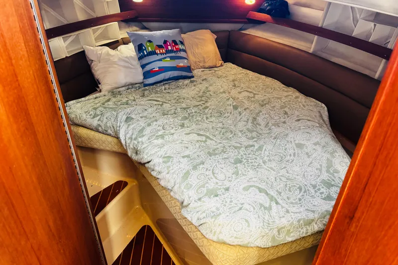 Slide: The Image of Cozy cabin interior of 2012 Ranger Tugs R-31 with a comfortable bed and decorative pillows. - 2