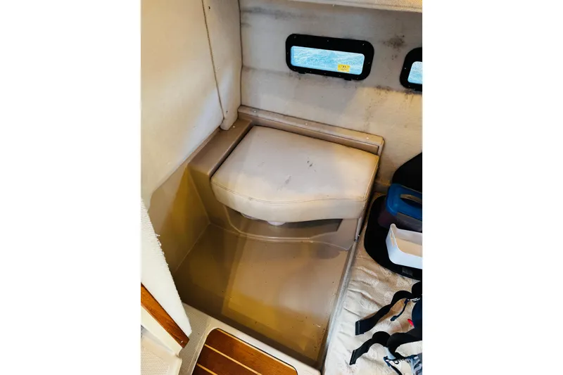 Slide: The Image of 2012 Ranger Tugs R-31 interior with cushioned seat and small windows. - 26