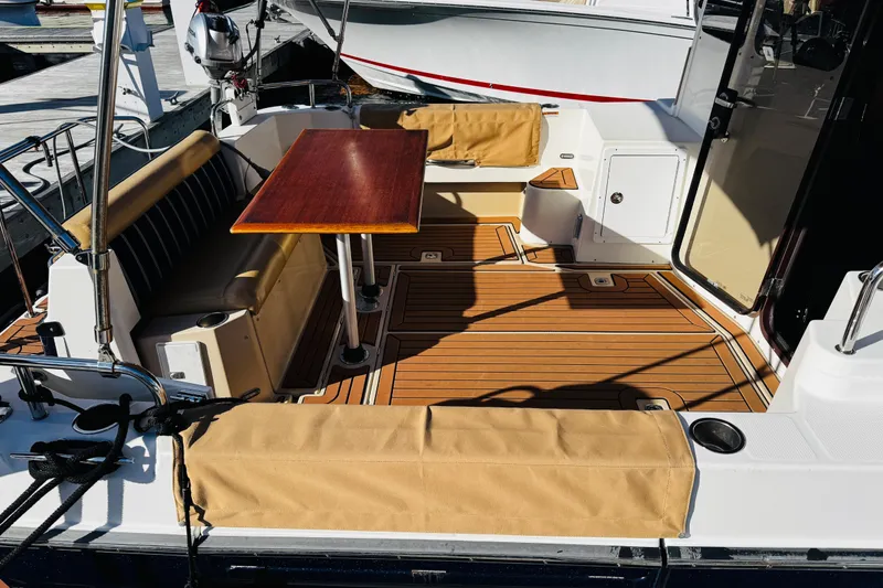 Slide: The Image of 2012 Ranger Tugs R-31 boat deck with seating and wooden table. - 28