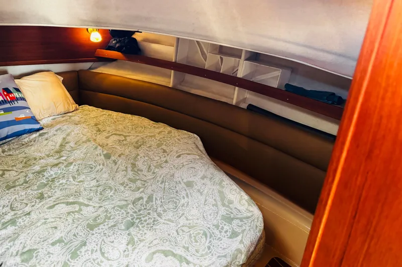 Slide: The Image of Cozy cabin interior of 2012 Ranger Tugs R-31 with patterned bedding and warm lighting. - 3