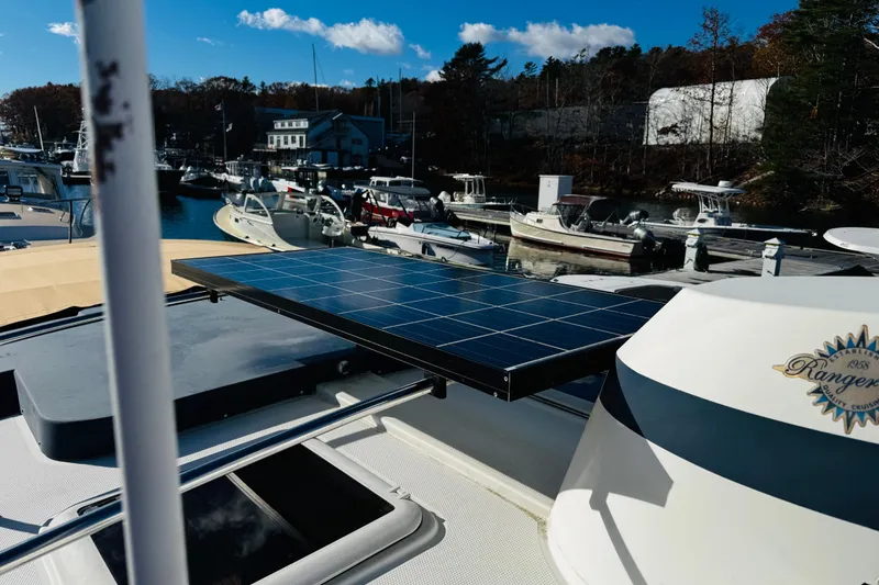 Slide: The Image of 2012 Ranger Tugs R-31 with solar panel at marina, surrounded by boats and trees. - 41