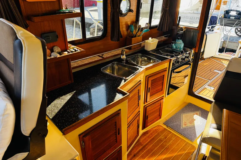 Slide: The Image of Interior of 2012 Ranger Tugs R-31 boat with wooden cabinetry and compact kitchen area. - 5