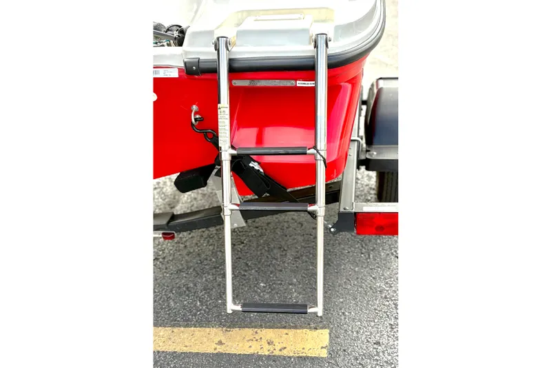 Slide: The Image of 2022 Bayliner Element M15 boat ladder on a trailer, red hull visible. - 11