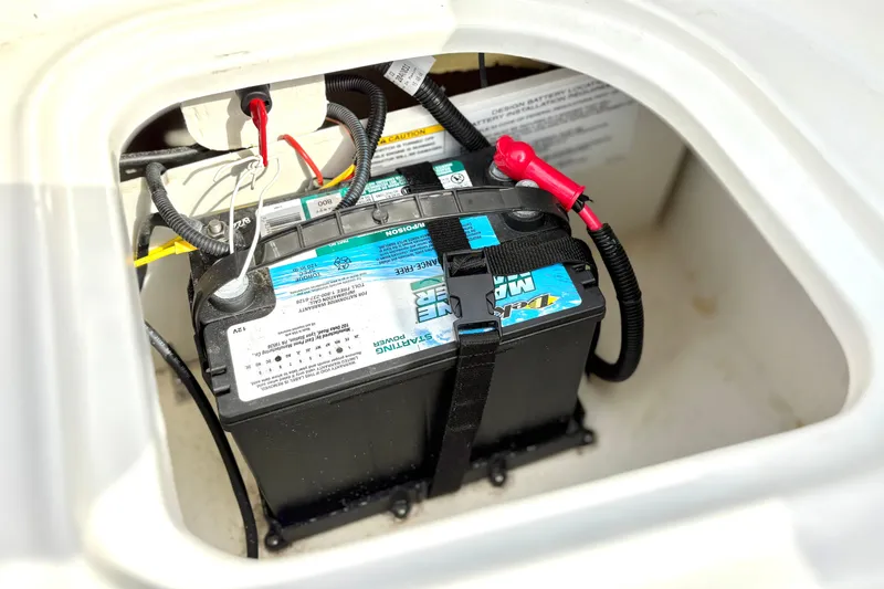 Slide: The Image of Battery compartment of 2022 Bayliner Element M15 boat with secured marine battery. - 34