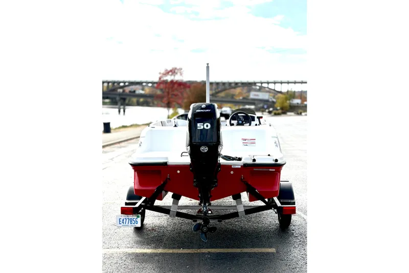 Slide: The Image of 2022 Bayliner Element M15 boat with Mercury 50 engine, parked near a river. - 8