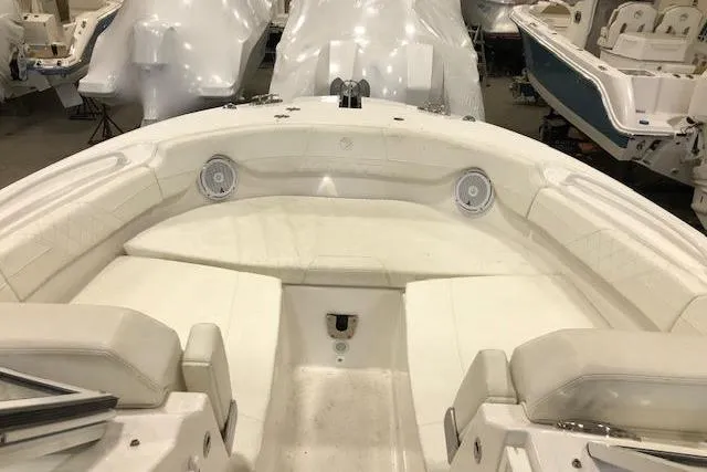 Slide: The Image of 2018 Edgewater 248CX Crossover boat interior with white seating and speakers. - 5