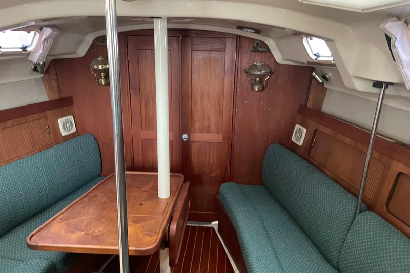 Slide: The Image of 1989 Hunter 35.5 sailboat interior with wood paneling and green upholstered seating. - 15