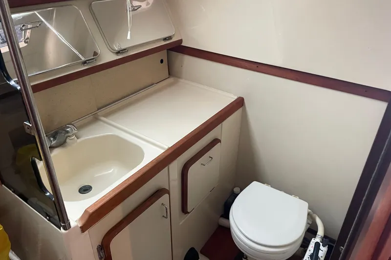 Slide: The Image of Compact bathroom in 1989 Hunter 35.5 sailboat with sink, toilet, and storage cabinets. - 17