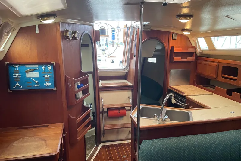 Slide: The Image of Interior of 1989 Hunter 35.5 sailboat with wood cabinetry and compact kitchen area. - 29