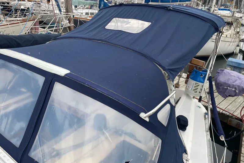 Slide: The Image of 1989 Hunter 35.5 sailboat with blue canvas cover docked at marina. - 4