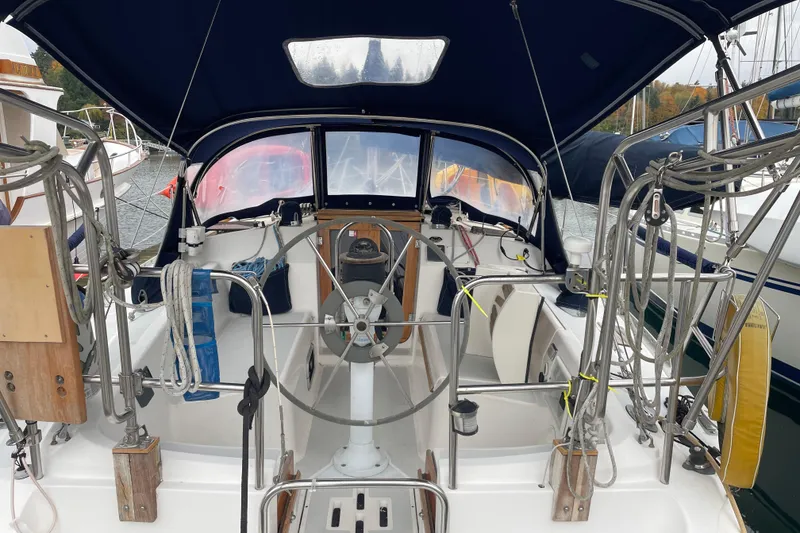 Slide: The Image of 1989 Hunter 35.5 sailboat cockpit with steering wheel and canopy in marina. - 5
