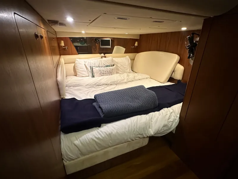 Slide: The Image of Luxurious cabin interior of 2006 Tiara Yachts Sovran, featuring cozy bedding and elegant wood paneling. - 11