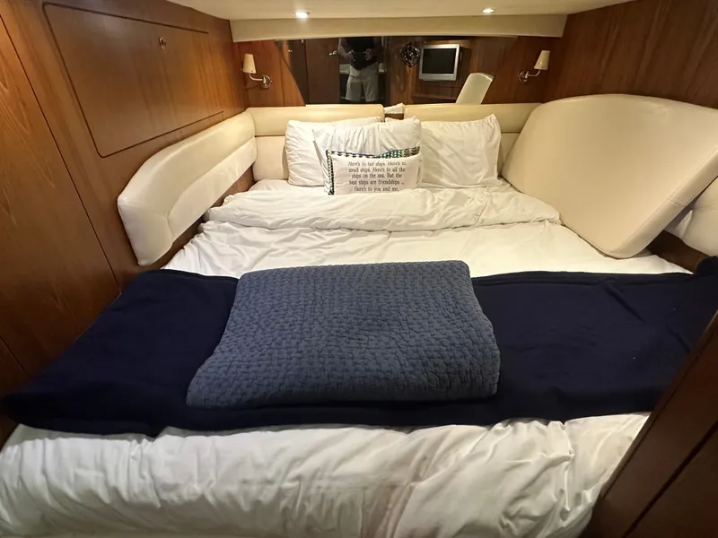 Slide: The Image of Luxurious 2006 Tiara Yachts Sovran cabin with cozy bedding and elegant wood paneling. - 14