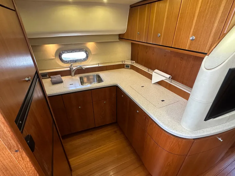 Slide: The Image of Luxurious 2006 Tiara Yachts Sovran kitchen with wood cabinetry and modern amenities. - 6