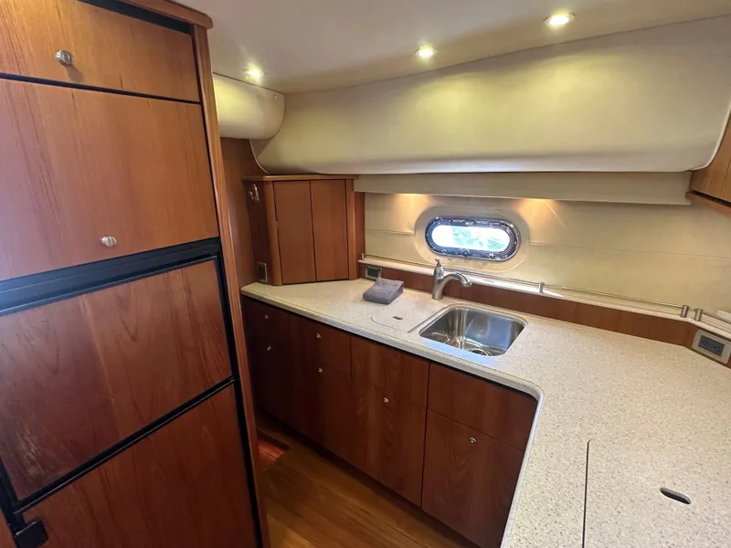 Slide: The Image of 2006 Tiara Yachts Sovran kitchen with wood cabinetry, sink, and porthole window. - 7
