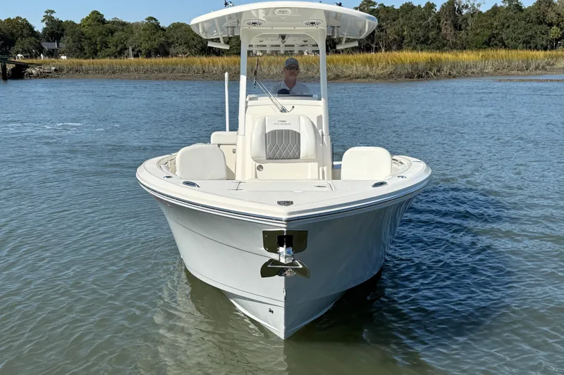 Slide: The Image of 2023 Cobia 240CC boat on calm water, showcasing sleek design and modern features. - 13