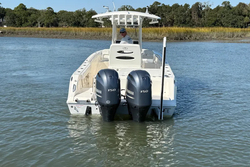 Slide: The Image of 2023 Cobia 240CC boat with dual Yamaha 150 engines on calm water. - 14