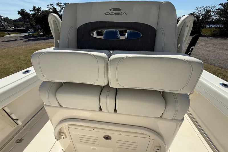 Slide: The Image of 2023 Cobia 240CC boat seating with white cushioned upholstery. - 21