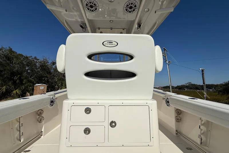 Slide: The Image of 2023 Cobia 240CC boat interior with storage compartments and seating, under clear blue sky. - 22