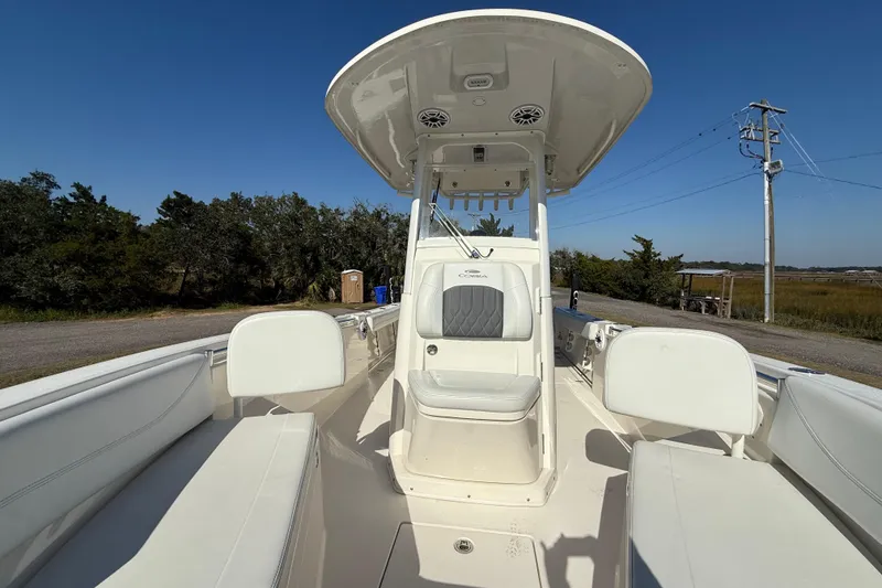 Slide: The Image of 2023 Cobia 240CC boat interior with seating and console, set against a clear blue sky. - 24