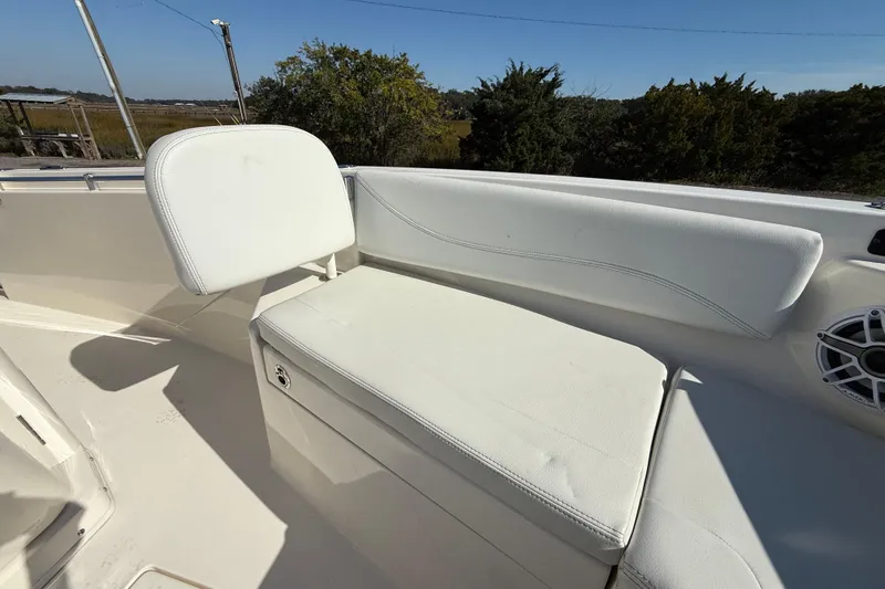 Slide: The Image of 2023 Cobia 240CC boat with white cushioned seating and speaker, outdoor setting. - 26