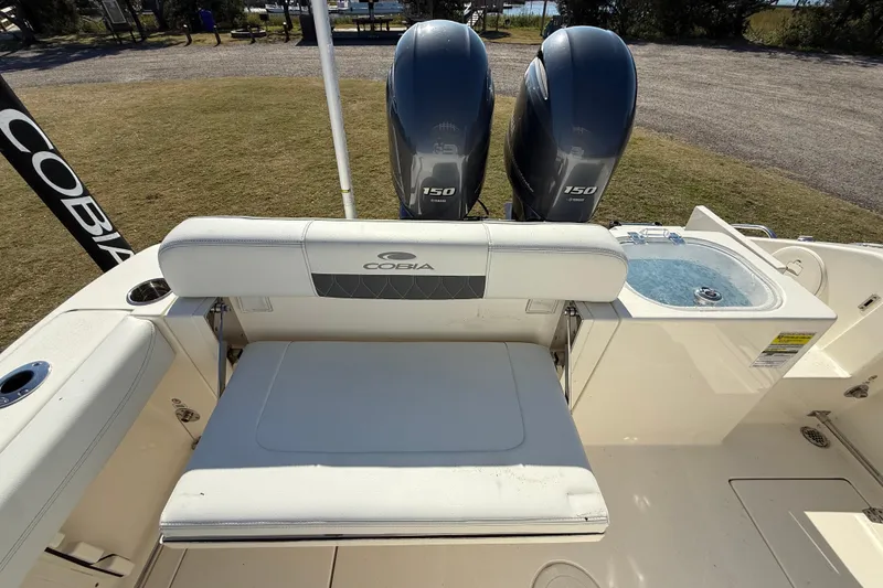 Slide: The Image of 2023 Cobia 240CC boat with dual engines and seating area, featuring a livewell. - 29