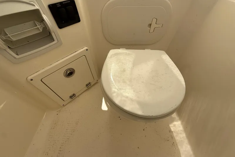 Slide: The Image of 2023 Cobia 240CC boat interior with toilet and storage compartments. - 31