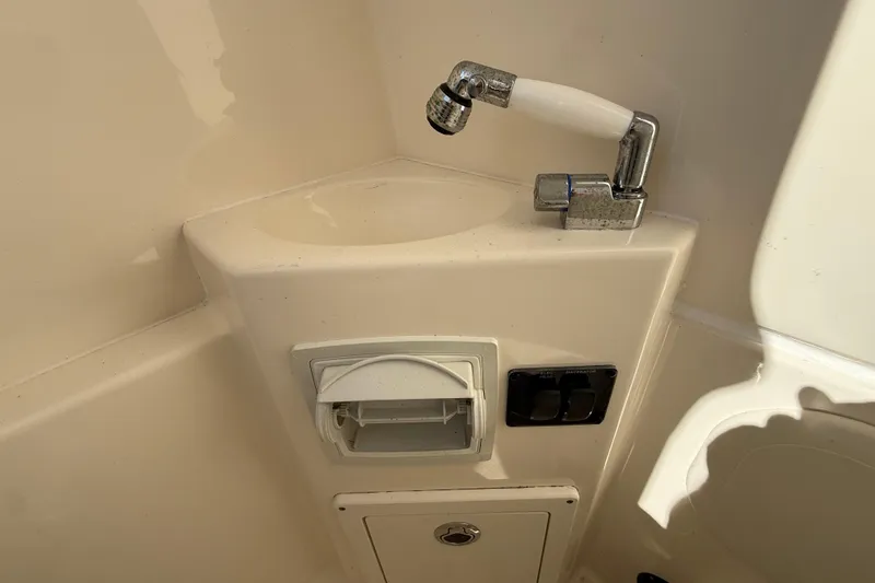 Slide: The Image of 2023 Cobia 240CC boat sink and control panel detail. - 32