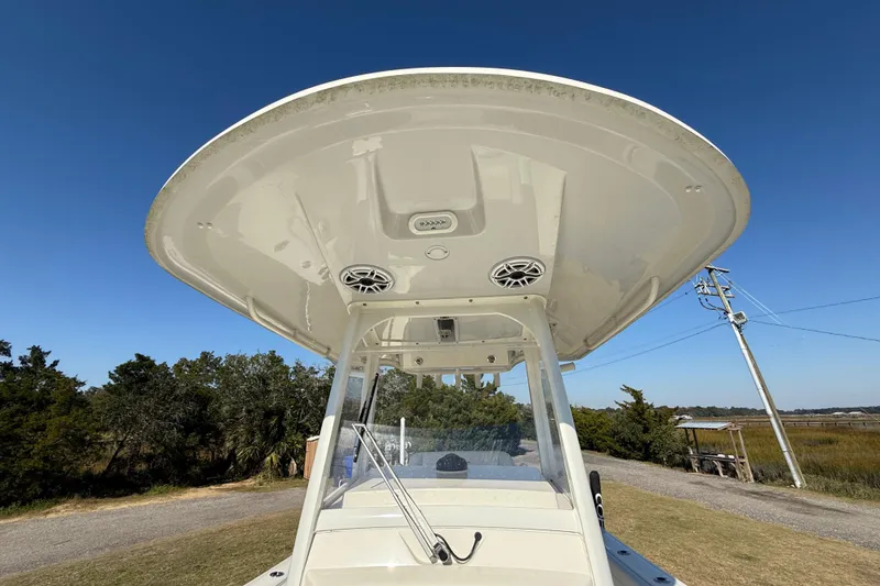 Slide: The Image of 2023 Cobia 240CC boat with T-top and speakers, set against a clear blue sky. - 33