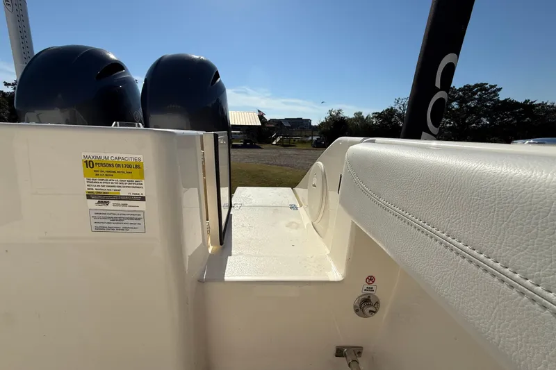 Slide: The Image of 2023 Cobia 240CC boat interior with seating and capacity label, sunny day. - 36