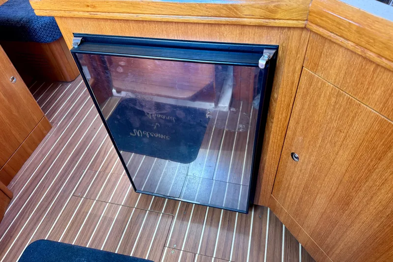 Slide: The Image of Wooden interior of a 2003 Hunter 36 yacht with a compact fridge. - 12