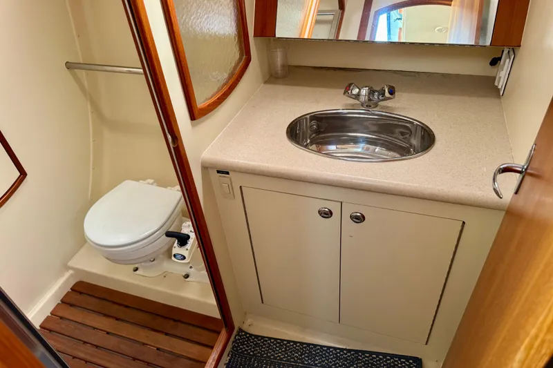 Slide: The Image of 2003 Hunter 36 yacht bathroom with sink, toilet, and wooden floor accents. - 17