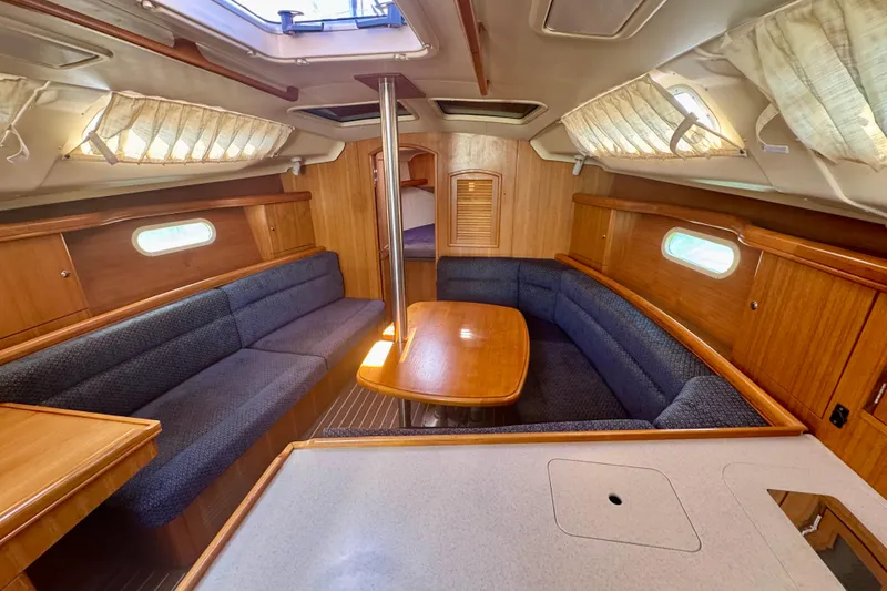Slide: The Image of Interior of a 2003 Hunter 36 sailboat with wood finish and cozy seating area. - 5
