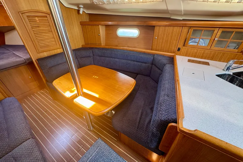 Slide: The Image of Interior of 2003 Hunter 36 sailboat with wooden dining area and seating. - 6