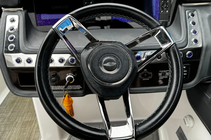 Slide: The Image of Steering wheel of a 2020 Chaparral 277 SSX boat, featuring modern controls and sleek design. - 20