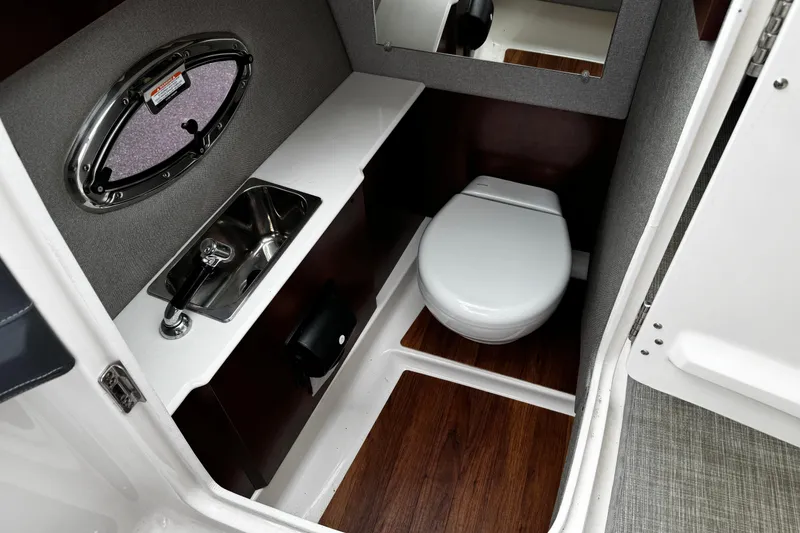 Slide: The Image of 2020 Chaparral 277 SSX boat interior with sink, toilet, and wood flooring. - 24