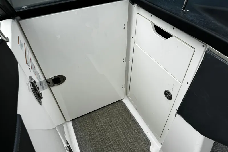 Slide: The Image of Interior view of 2020 Chaparral 277 SSX boat, featuring a sleek white storage compartment. - 27